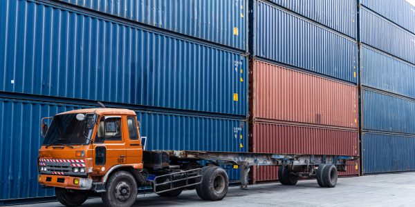 Background of truck at container warehouse preparing to lift cargo boxes. Logistics shipping delivery business. banner size with copy space